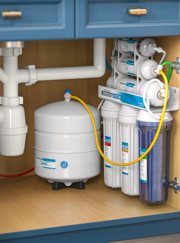Reverse osmosis water purification system under sink in a kitchen.